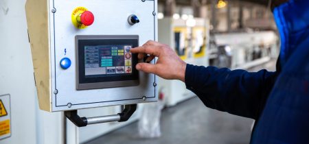 worker uses control panel in factory