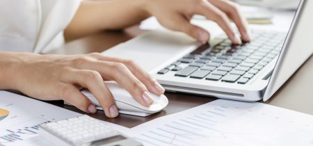 Woman using a mouse working on the computer