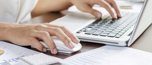 Woman using a mouse working on the computer