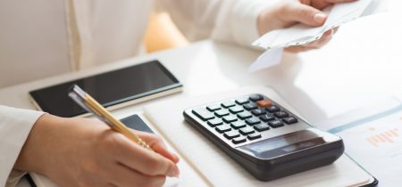 Closeup of person holding bills and calculating them
