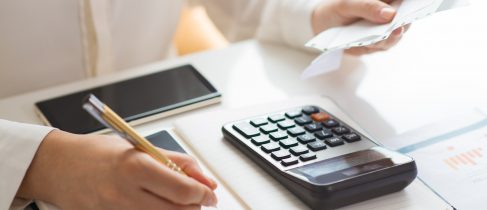 Closeup of person holding bills and calculating them