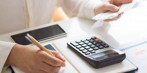 Closeup of person holding bills and calculating them